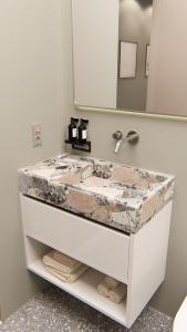 a bathroom with a marble sink and a mirror at Nixon Downtown, a member of Nixon Hotels in Athens