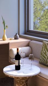 a bottle of wine on a table with two glasses at Nixon Downtown, a member of Nixon Hotels in Athens