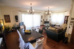 una sala de estar con una mesa y un sofá en Jenny Villas, en Kriopigi