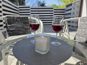 zwei Gläser Wein und eine Kerze auf einem Tisch in der Unterkunft Studiouri Techirghiol in Techirghiol + 19 Fotos