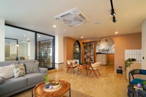 a living room with a couch and a table at Olive Hotel Nagawara by Embassy Group in Bangalore