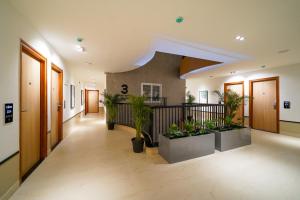 a hallway with potted plants in a building at Olive Hotel Nagawara by Embassy Group in Bangalore