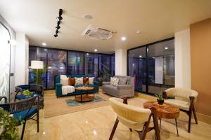 a living room with a couch and chairs at Olive Hotel Nagawara by Embassy Group in Bangalore