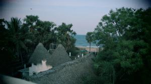 a view of a beach with a building and trees at Moon Hug Boutique Beach House in Auroville