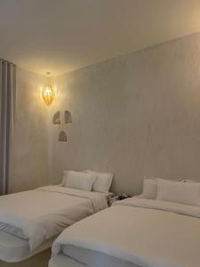 two beds sitting next to each other in a room at Athens Resort in Madīnat an Nahḑah +82 photos