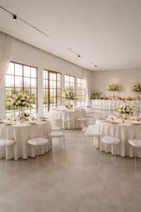 a room with white tables and chairs with flowers at Athens Resort in Madīnat an Nahḑah