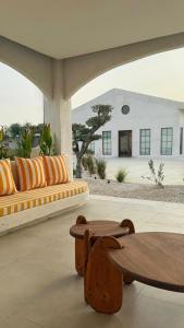 a patio with benches and a table and a building at Athens Resort in Madīnat an Nahḑah