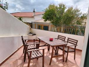 a patio with a table and chairs on a balcony at Casa da Boa Vista in Bordeira
