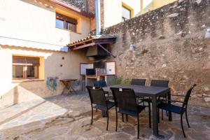 a patio with a table and chairs in front of a building at Hauzify I Casa Rourell in El Morell