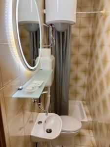 a small bathroom with a toilet and a mirror at Rooms Nada in Senj
