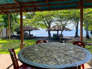 a table with chairs and a view of the water at Ghia Boutique Homestay in Batuangus