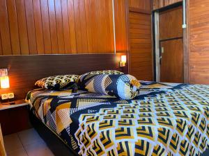 a bedroom with a bed with a wooden wall at Ghia Boutique Homestay in Batuangus
