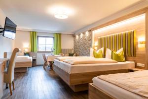 a hotel room with two beds and a television at Gasthof Metzgerei Stöberl in Lam