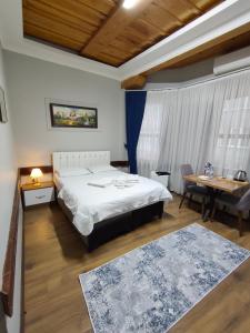 ein Schlafzimmer mit einem Bett, einem Tisch und einem Schreibtisch in der Unterkunft Kule Pansiyon in Bursa