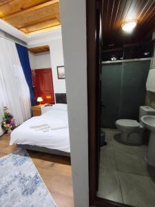 ein Schlafzimmer mit Bett, Toilette und Waschbecken in der Unterkunft Kule Pansiyon in Bursa