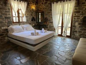 a bedroom with a large bed in a room with windows at Paros Casa Prive in Vrachonisída Loúmpinas