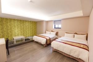 Un pat sau paturi într-o cameră la 宜都大飯店 Idol Hotel