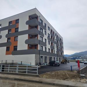 a building with a parking lot with cars parked in it at Nora in Žepče