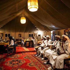 a group of people sitting in a tent at Rosara Luxury Camp in Merzouga