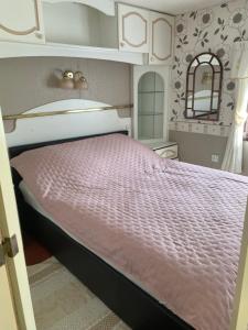 a bedroom with a bed with a pink comforter at Marcyzakątek in Marcyporęba