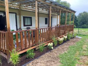 a house with a wooden deck with plants at Marcyzakątek in Marcyporęba +3 photos