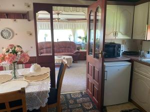 a kitchen and living room with a table and a kitchen and a caravan at Marcyzakątek in Marcyporęba