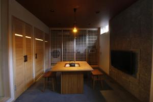 a room with a table with chairs and a television at Yanaka Kotobuki Sou in Tokyo