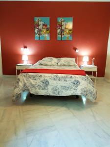 een slaapkamer met een groot bed in een rode muur bij Apartamento Venecia Arenal in Sevilla