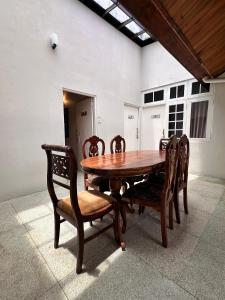 a wooden table and chairs in a room at Villa i in Dehiwala