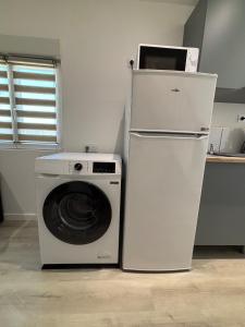 a refrigerator and a washing machine in a kitchen at Chez Mimi in Maubert-Fontaine