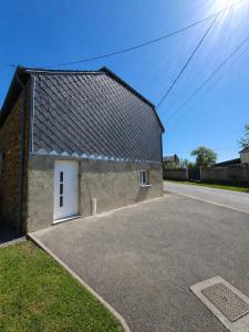 a building with a white door on the side of it at Chez Mimi in Maubert-Fontaine