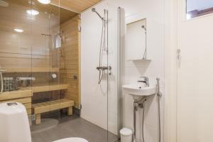 a bathroom with a shower and a toilet and a sink at City & Forest Relax Room with Private Sauna & Garden in Espoo