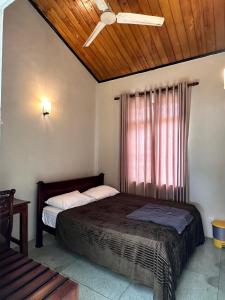 a bedroom with a bed and a window with a ceiling at Villa i in Dehiwala