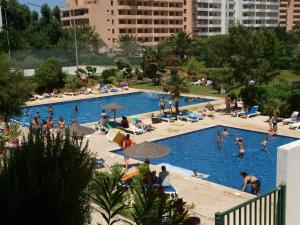 a swimming pool with several people in it at Apartamentos Jardins da Rocha in Portimão