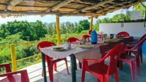a table with red chairs sitting on a patio at Complexo Alemanha - Vilanculos Backpacker in Vilanculos