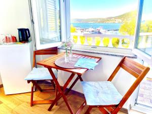 a table and two chairs in a kitchen with a window at Villa Csery 1stzime in Supetarska Draga