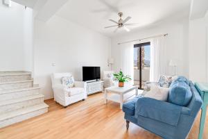 a living room with a blue couch and a tv at 4 Bedroom Villa With Private Pool in Maroni