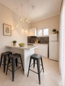 a kitchen with a table and stools in a room at Villa Joanna in Vasilikos