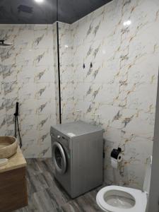 a bathroom with a toilet and a washing machine at Квартира возле стадиона in Kobuleti +25 photos