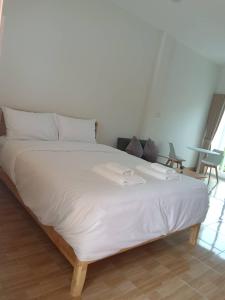 a large white bed with a tray on top of it at MUJISTAY Hotel มูจิสเตย์โฮเทล in Ban Non Than
