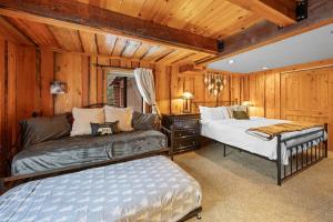 a bedroom with two beds and a couch in it at Modern Log Home-Walk2Slopes&Trails-Spa-Arcade-EVch in Big Bear Lake