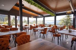 a restaurant with tables and chairs and windows at Grand Hotel Belushi in Boge