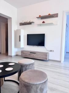 a living room with two stools and a flat screen tv at Nico's Place in Sînpetru