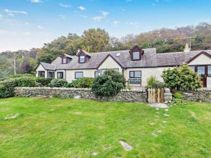 a large white house with a stone wall at 3 Bed in Isle Of Arran oc-93240 in Pirnmill