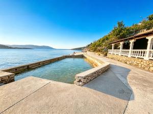 a swimming pool next to a body of water at My Miracle Stinica in Stinica