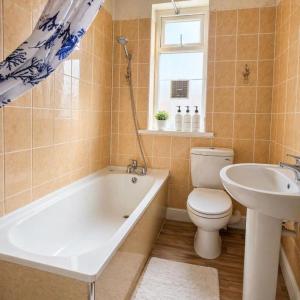 a bathroom with a tub and a toilet and a sink at The Range Nestled Nook in Manchester +11 photos