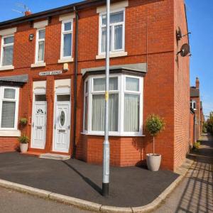 a red brick building with white doors on a street at The Range Nestled Nook in Manchester