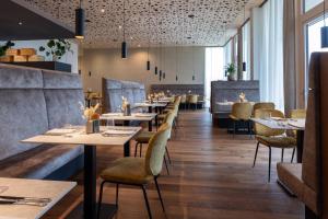 a dining room with tables and chairs and windows at CIRCLE Boutique Hotel Melk in Melk