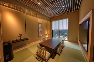 a dining room with a table and a television at 鴨川せせらぎ庵 in Kyoto