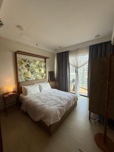 a bedroom with a bed and a large window at Ecosea Timurbay in Kampong Tanjong